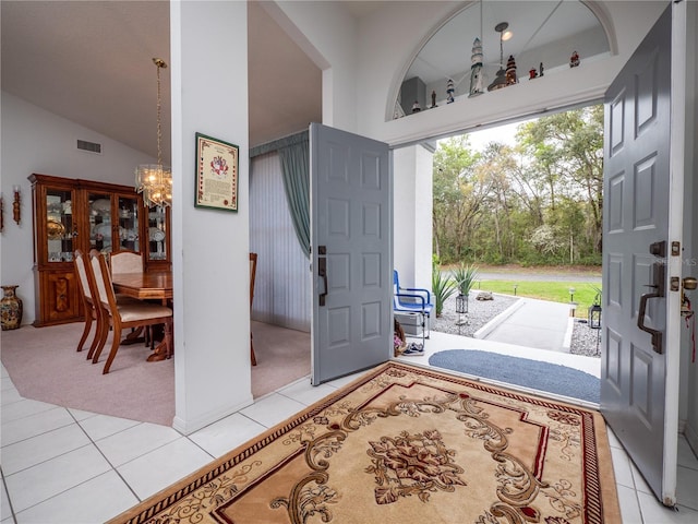 tiled entrance foyer with a notable chandelier and high vaulted ceiling