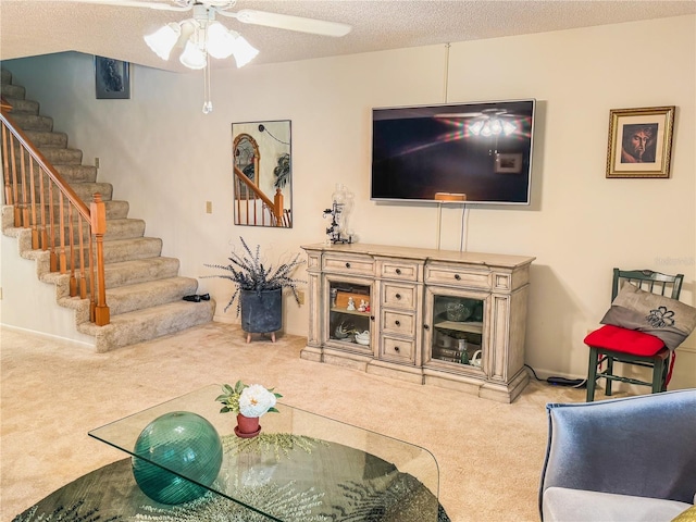 carpeted living room featuring a textured ceiling and ceiling fan