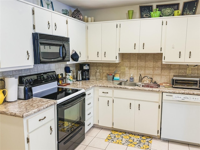 kitchen with light tile floors, backsplash, black appliances, and sink