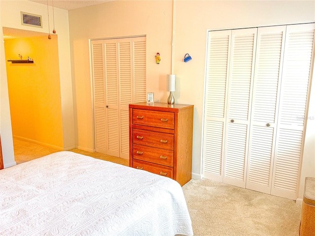 carpeted bedroom with multiple closets