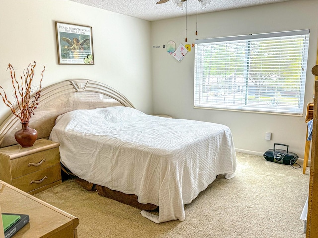 carpeted bedroom featuring ceiling fan and a textured ceiling