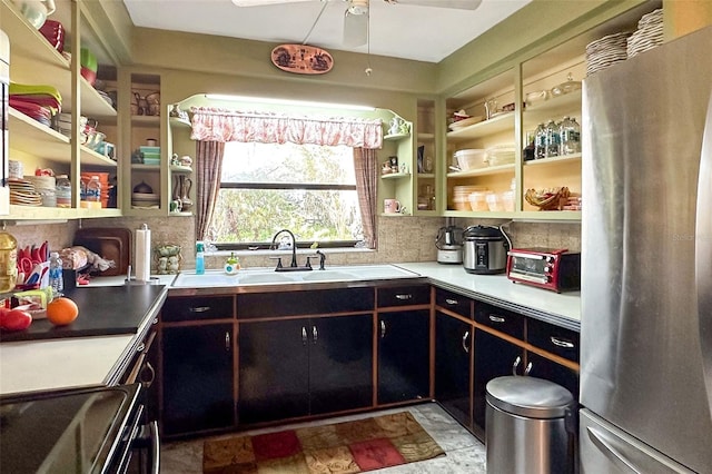 kitchen with range, ceiling fan, stainless steel fridge, light tile flooring, and tasteful backsplash