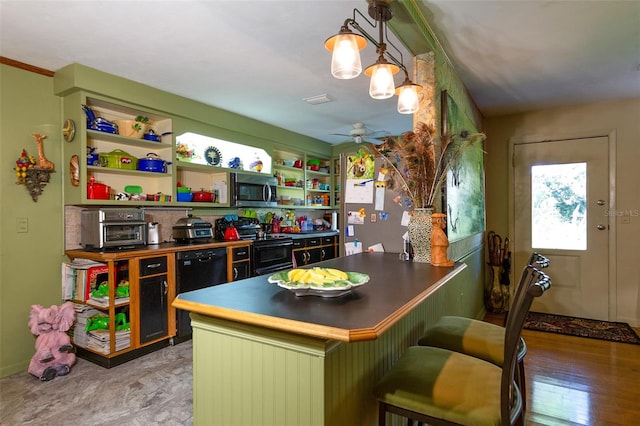 kitchen featuring a breakfast bar area, light hardwood / wood-style floors, black range with electric cooktop, decorative light fixtures, and ceiling fan with notable chandelier