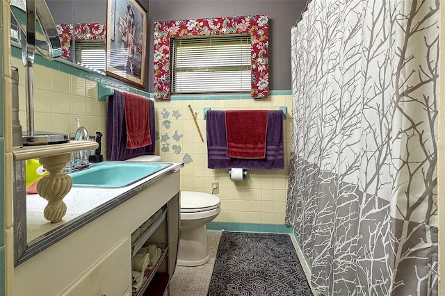 bathroom featuring tile walls, toilet, vanity, and tile flooring