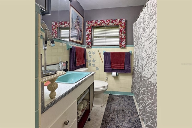 bathroom with tile walls, tile flooring, toilet, and vanity