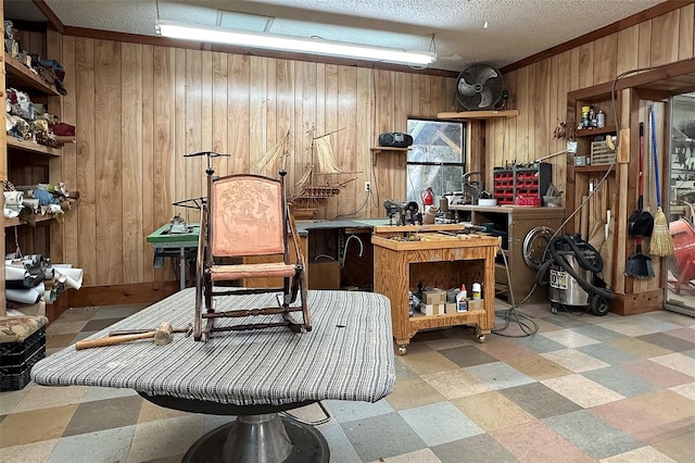 interior space with wood walls, a workshop area, and a textured ceiling