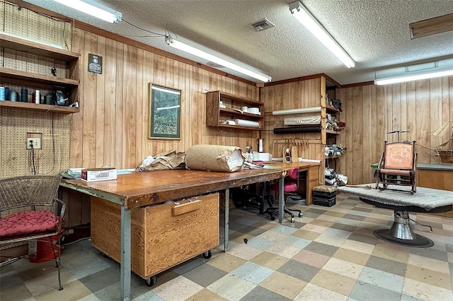 interior space with wood walls, a workshop area, and a textured ceiling