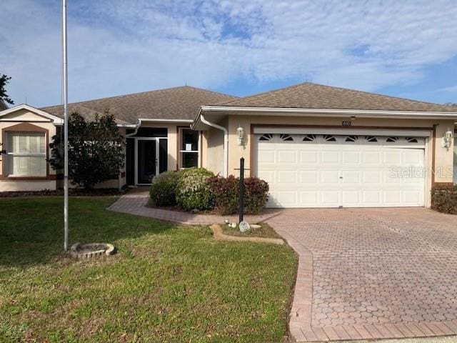 single story home with a front yard and a garage