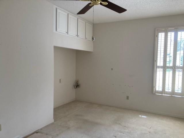 unfurnished room featuring ceiling fan and a textured ceiling