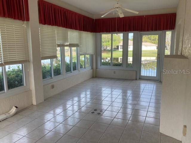 spare room featuring light tile floors and ceiling fan