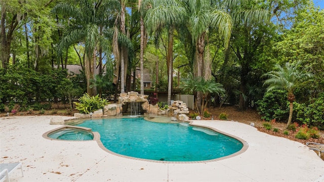 view of swimming pool with an in ground hot tub, pool water feature, and a patio