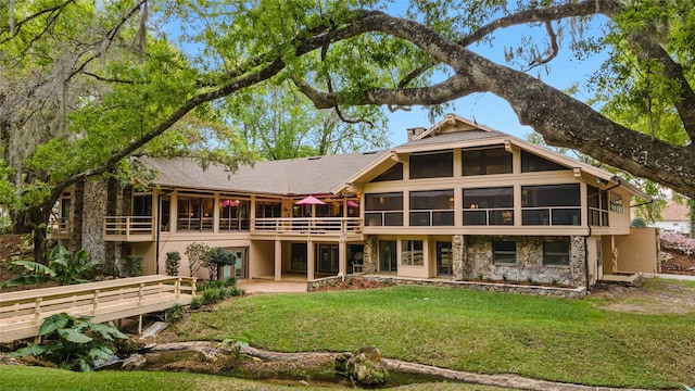 rear view of property featuring a sunroom and a yard