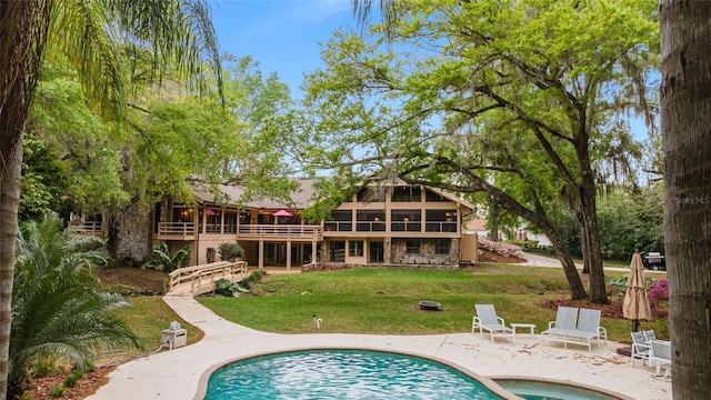 back of property with a lawn and a patio area