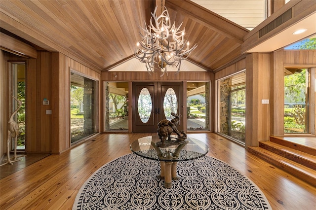 foyer featuring plenty of natural light, vaulted ceiling, and light wood-type flooring