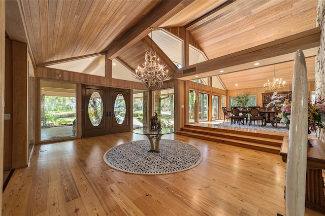 entryway featuring a notable chandelier, light wood-type flooring, beam ceiling, wooden ceiling, and french doors