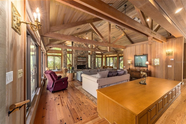 interior space featuring wood walls, a fireplace, wood ceiling, beamed ceiling, and light hardwood / wood-style flooring