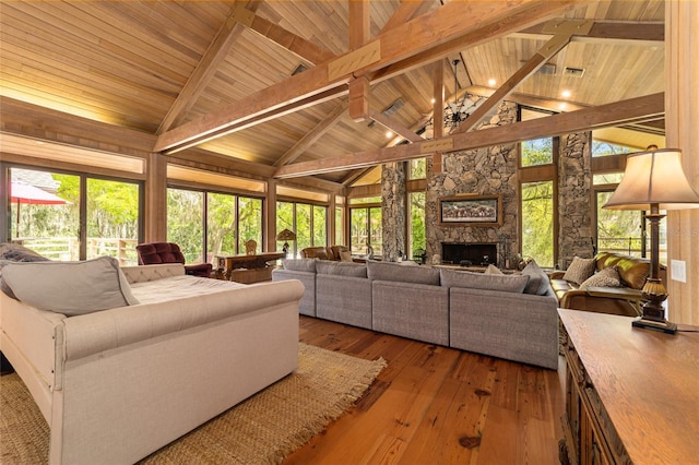 living room featuring beamed ceiling, high vaulted ceiling, wooden ceiling, a stone fireplace, and dark hardwood / wood-style flooring