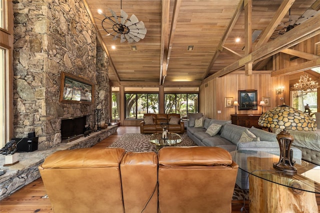 living room featuring wooden walls, wood ceiling, light hardwood / wood-style floors, a fireplace, and high vaulted ceiling