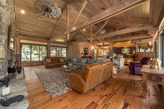 living room with wood ceiling, light hardwood / wood-style flooring, wood walls, high vaulted ceiling, and beam ceiling