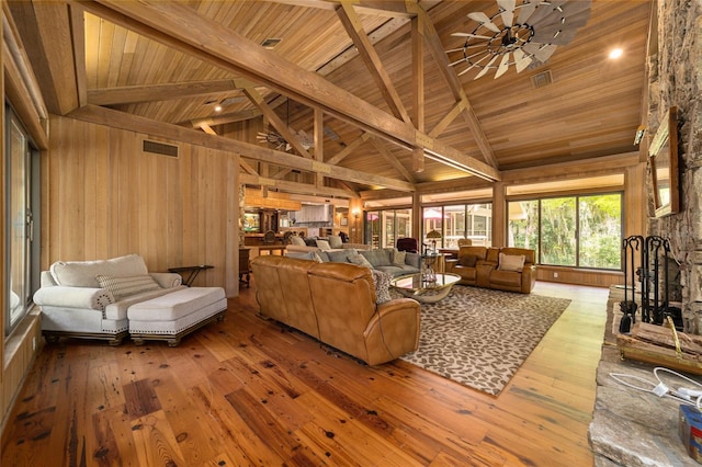 living room with wooden walls, ceiling fan, wooden ceiling, dark wood-type flooring, and high vaulted ceiling