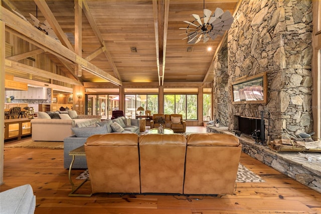 living room with wooden ceiling, light hardwood / wood-style floors, high vaulted ceiling, and a fireplace