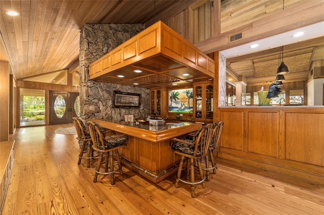 interior space featuring beamed ceiling, light hardwood / wood-style floors, wooden walls, wood ceiling, and pendant lighting