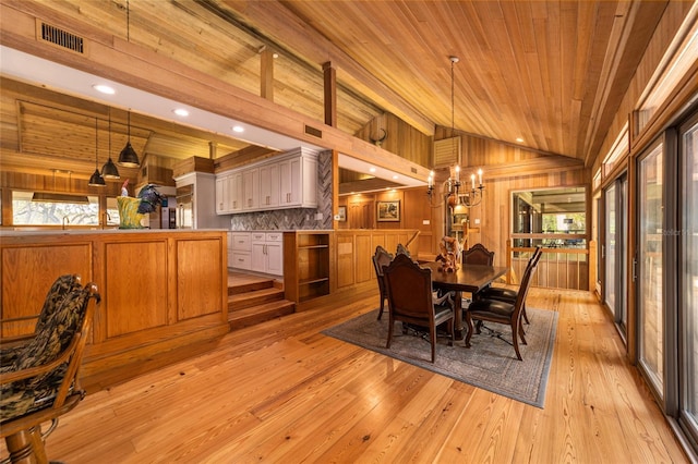 dining area with wooden ceiling, wooden walls, vaulted ceiling, and light hardwood / wood-style flooring