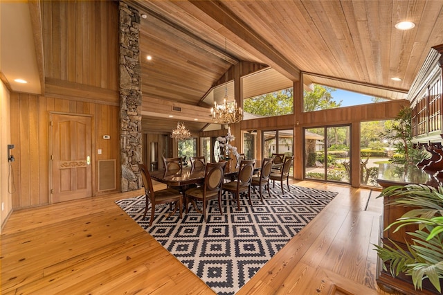 dining space with an inviting chandelier, high vaulted ceiling, light hardwood / wood-style floors, wood walls, and wood ceiling