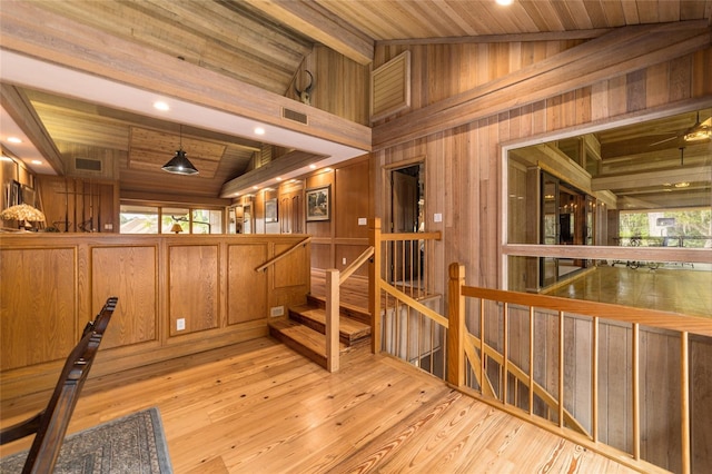 interior space featuring wood walls, high vaulted ceiling, wood ceiling, beamed ceiling, and light wood-type flooring