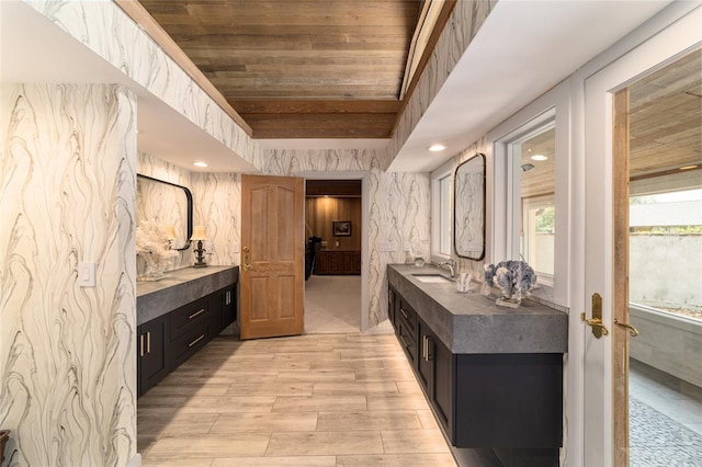 interior space featuring wooden ceiling, sink, a tray ceiling, and light hardwood / wood-style flooring