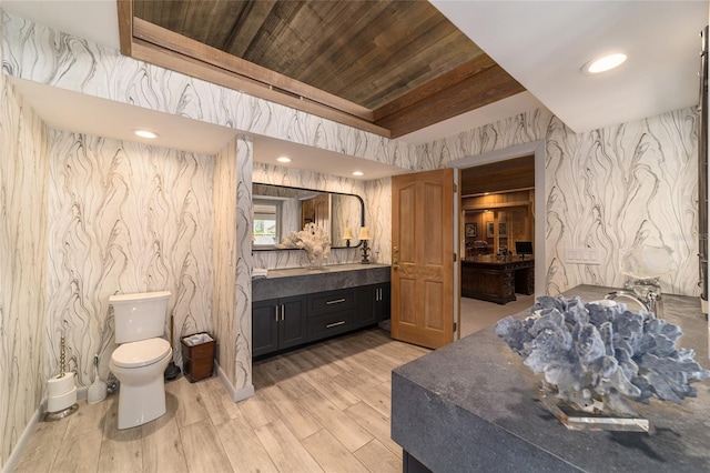 bathroom featuring hardwood / wood-style flooring, vanity, wooden ceiling, and toilet