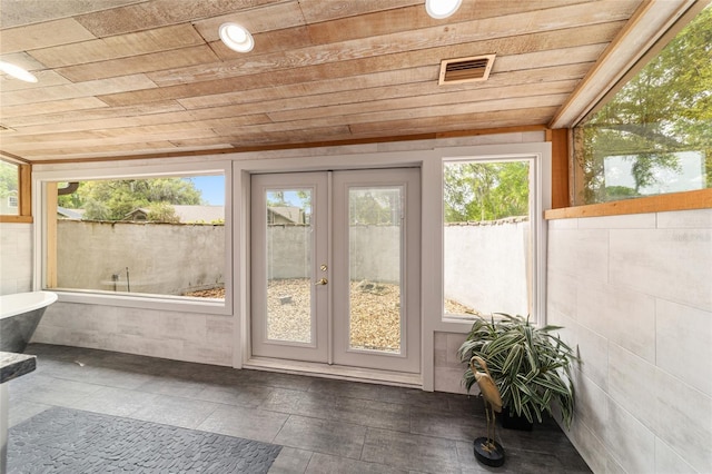 sunroom / solarium featuring a healthy amount of sunlight, wood ceiling, and french doors