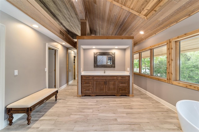 interior space featuring wood ceiling, vanity, a bath, and wood-type flooring