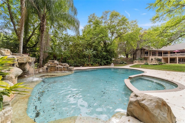 view of pool with an in ground hot tub and pool water feature