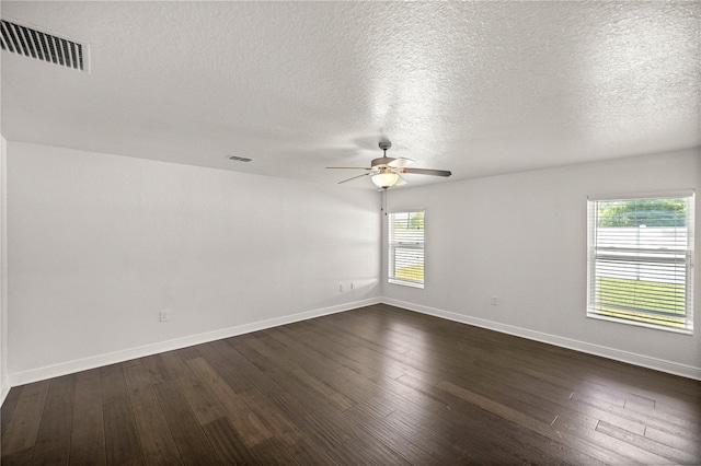 spare room with a textured ceiling, ceiling fan, and dark hardwood / wood-style flooring