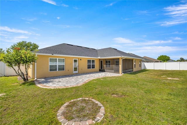 back of property with a lawn and a patio