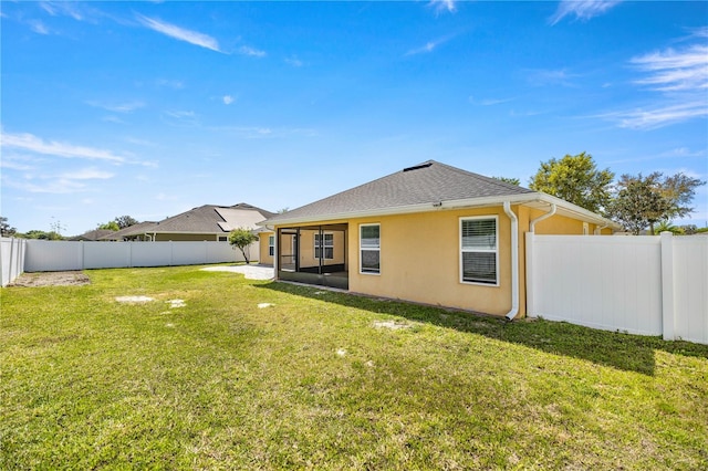 rear view of property featuring a lawn