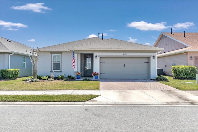 single story home featuring a front yard, a garage, and central air condition unit