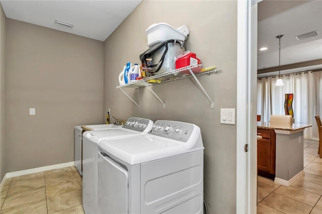 washroom featuring washing machine and dryer and light tile floors