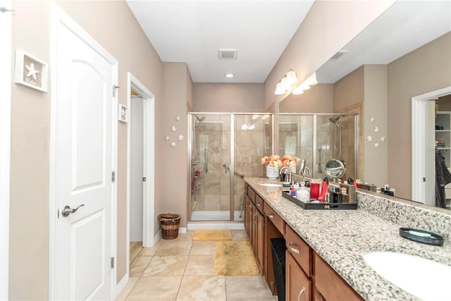 bathroom with dual bowl vanity, tile flooring, and a shower with shower door