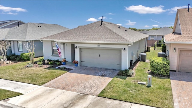 single story home with a front yard, a garage, and central AC unit