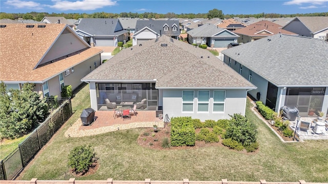 rear view of property with a yard, a sunroom, and a patio