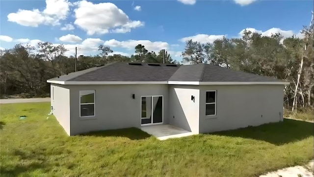 back of property featuring a lawn and a patio