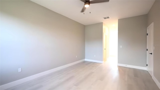 empty room with ceiling fan and light hardwood / wood-style flooring