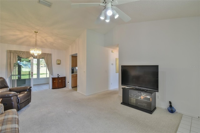 carpeted living room featuring vaulted ceiling and ceiling fan with notable chandelier