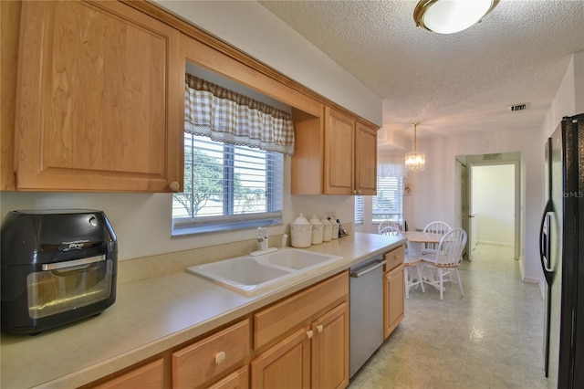 kitchen featuring black refrigerator, sink, a textured ceiling, dishwasher, and pendant lighting