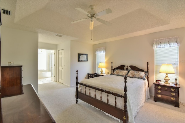 bedroom featuring ceiling fan, a raised ceiling, light carpet, a textured ceiling, and a closet