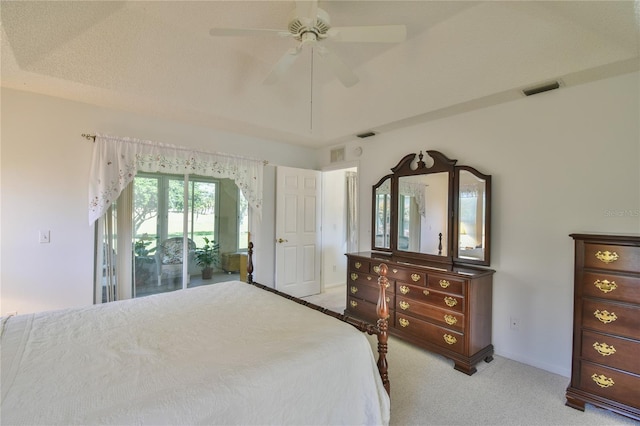 bedroom with a raised ceiling, light colored carpet, ceiling fan, and access to outside