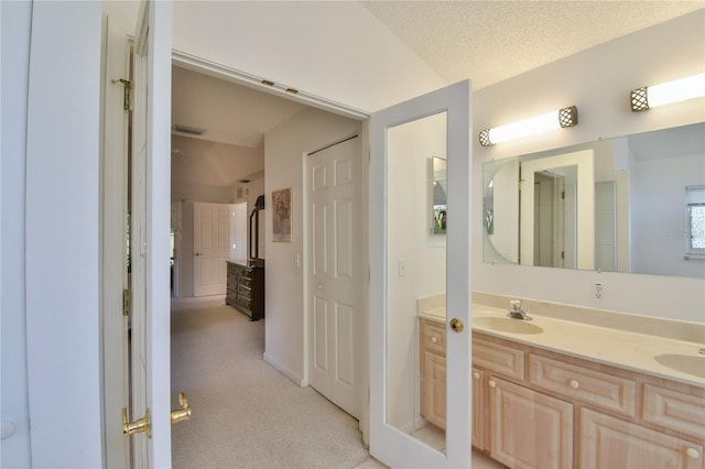 bathroom with dual vanity and a textured ceiling