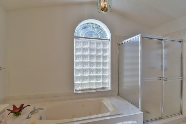 bathroom featuring vaulted ceiling, separate shower and tub, and a textured ceiling